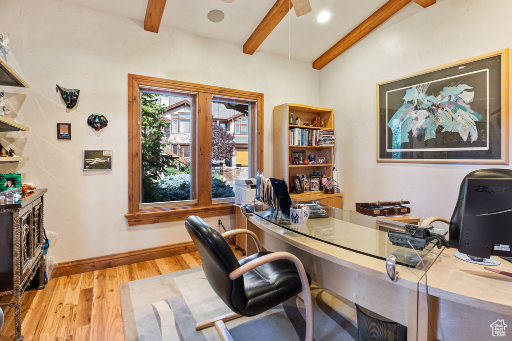 Office space featuring beamed ceiling, light wood finished floors, and a ceiling fan