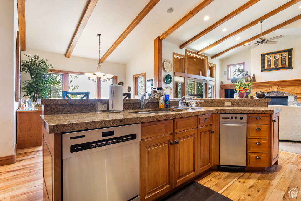 Kitchen with dishwasher, open floor plan, light wood finished floors, brown cabinets, and a chandelier