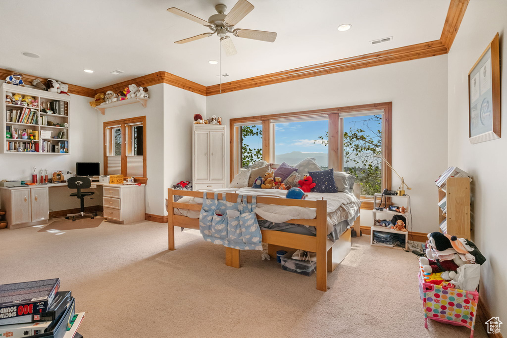 Bedroom featuring ornamental molding, light carpet, recessed lighting, built in study area, and a ceiling fan