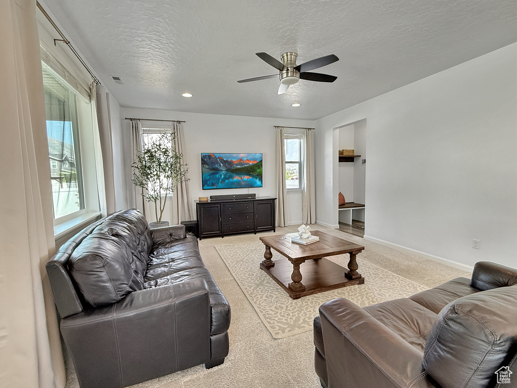 Living room featuring a ceiling fan, a textured ceiling, carpet flooring, and recessed lighting