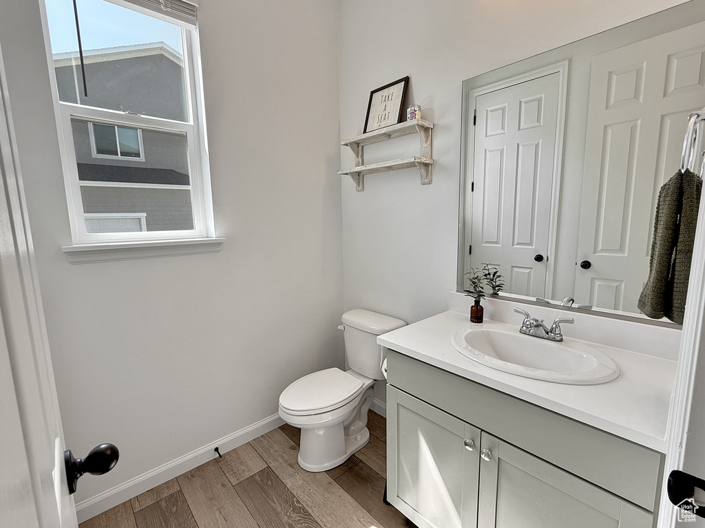 Half bathroom with vanity and wood finished floors