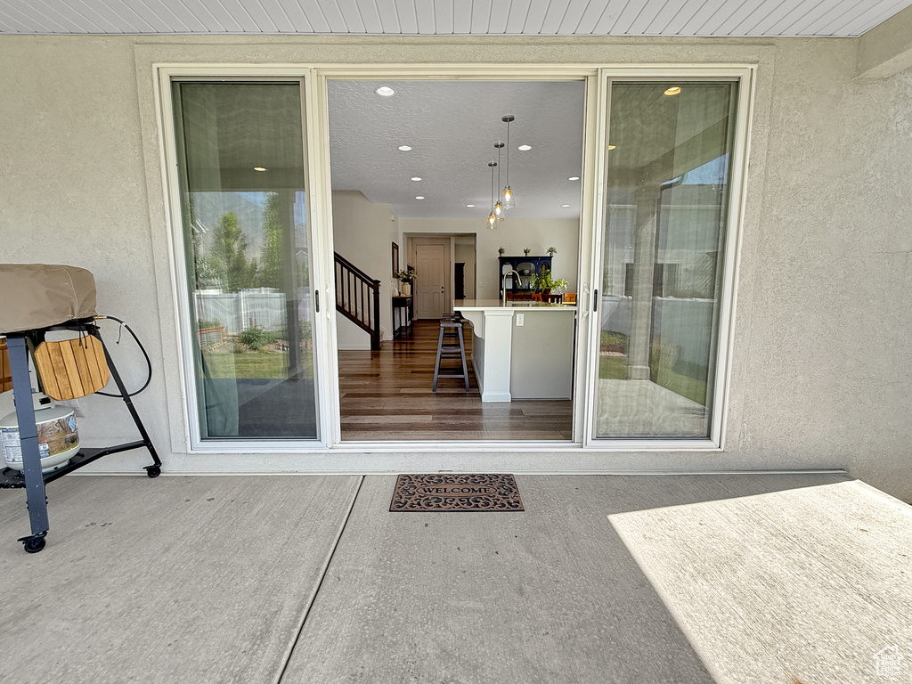 Entrance to property with stucco siding and a sink