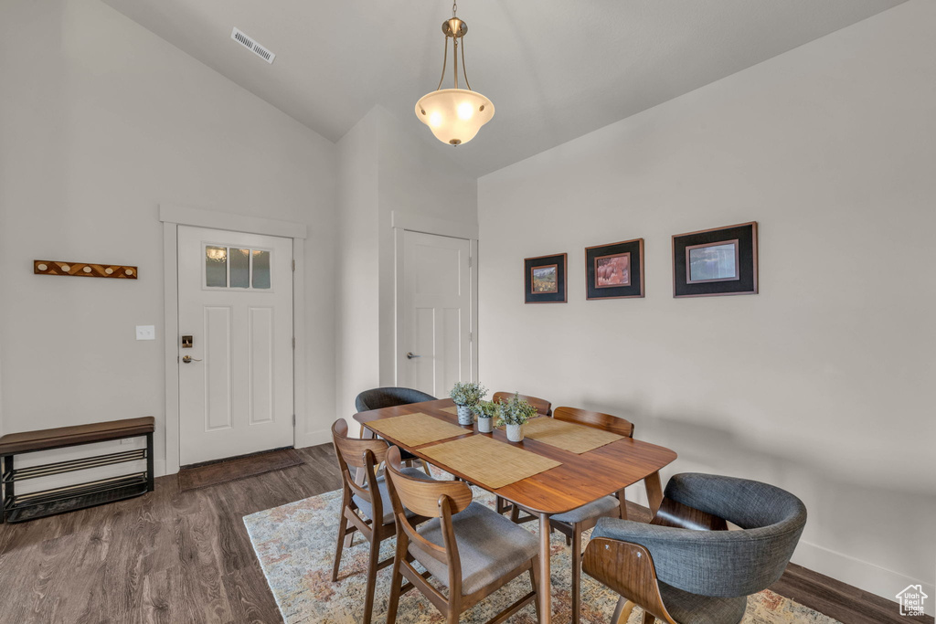 Dining room featuring wood finished floors and high vaulted ceiling