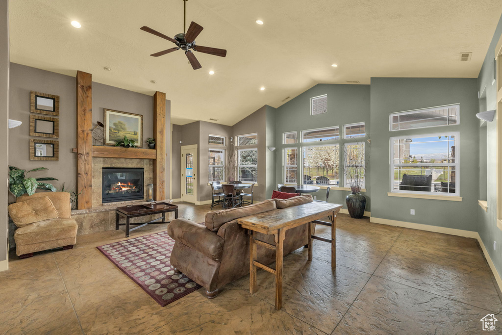 Living room featuring a glass covered fireplace, healthy amount of natural light, a ceiling fan, recessed lighting, and high vaulted ceiling