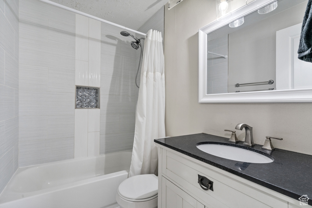Full bathroom with shower / bath combo with shower curtain and vanity