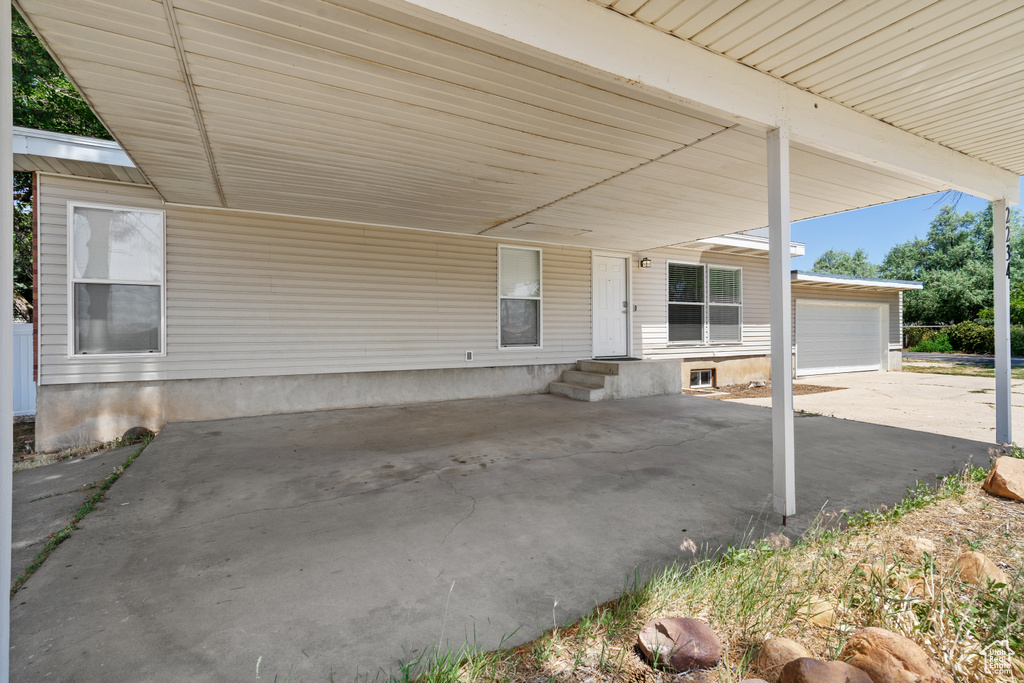 View of patio / terrace featuring a garage and an attached carport