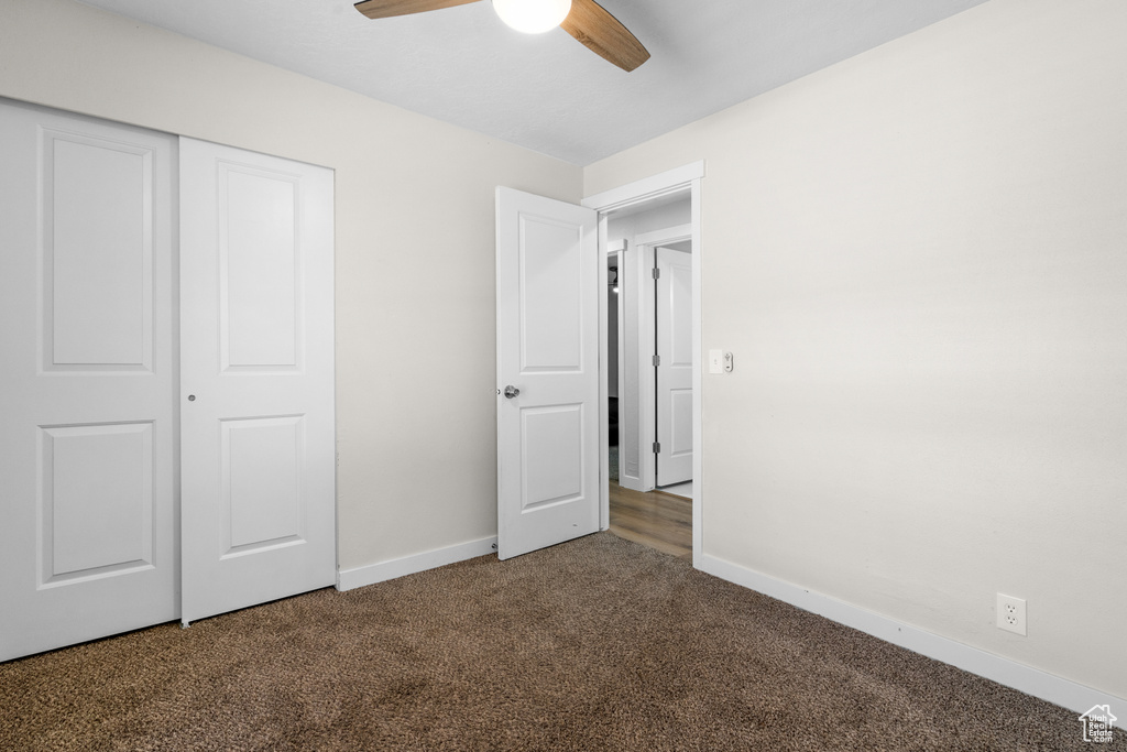 Unfurnished bedroom with carpet flooring, a closet, and a ceiling fan