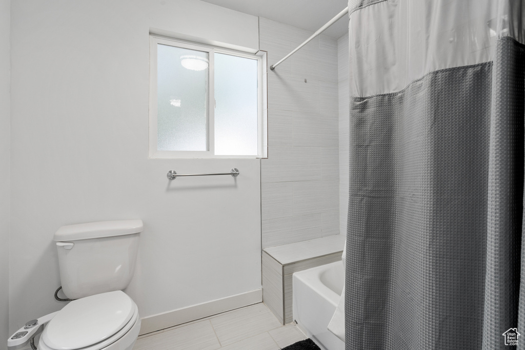 Bathroom with shower / tub combo and tile patterned flooring