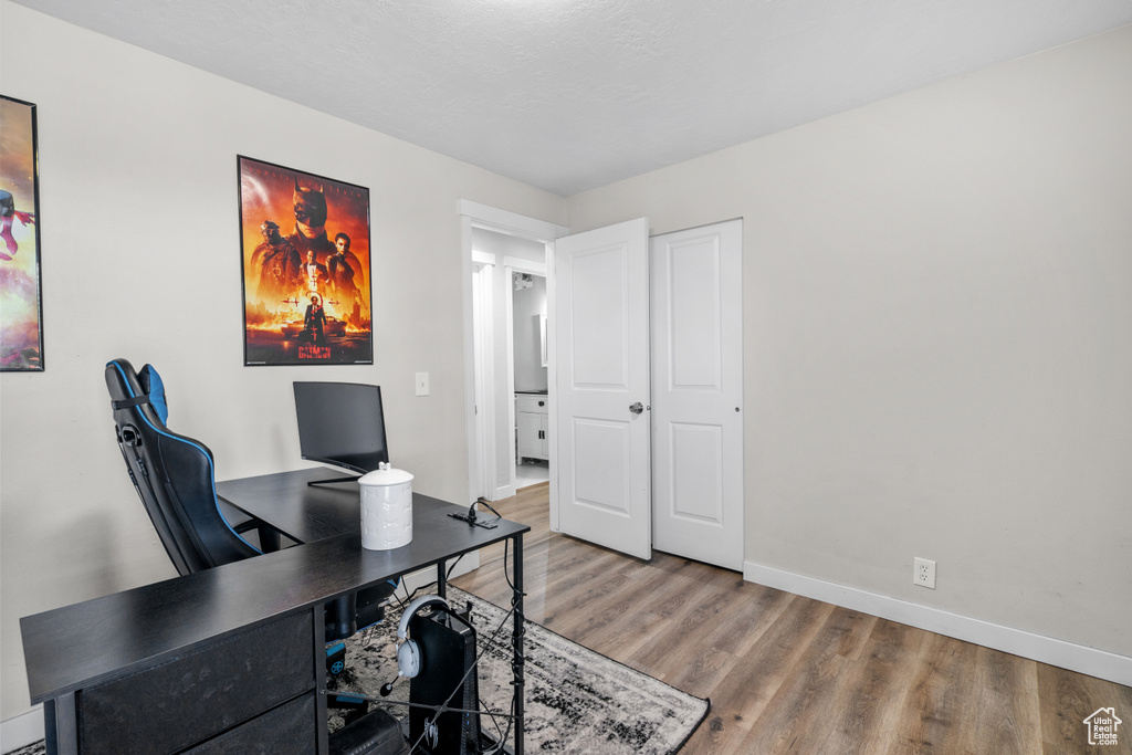 Office space with light wood-type flooring and baseboards