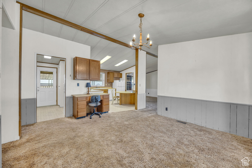 Office area featuring light carpet, a chandelier, and wainscoting