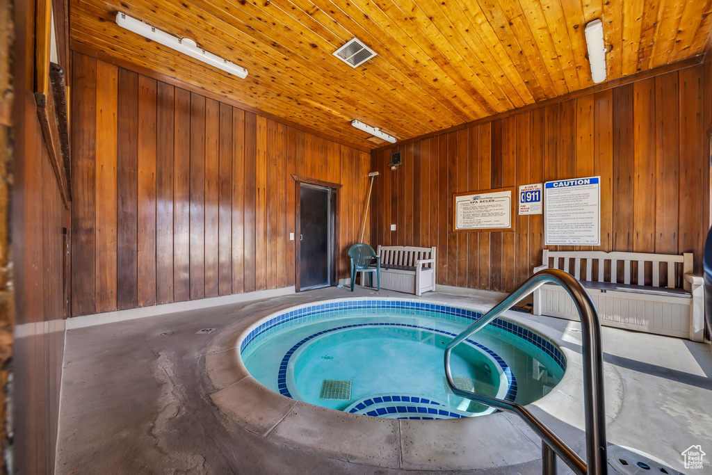 View of swimming pool with a hot tub