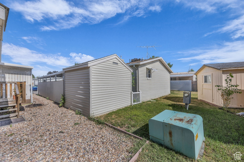 View of home\'s exterior with a shed and a yard