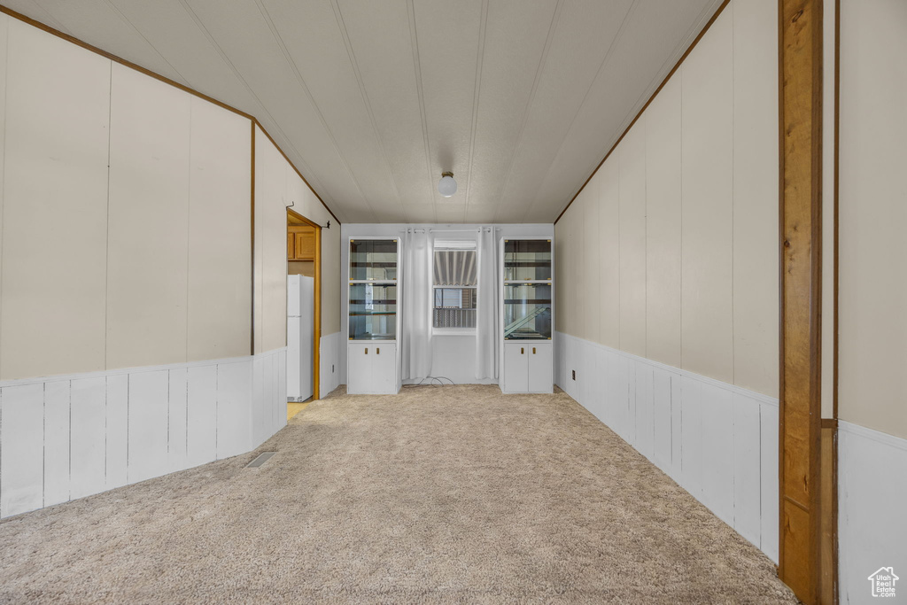 Carpeted spare room with a decorative wall and a wainscoted wall