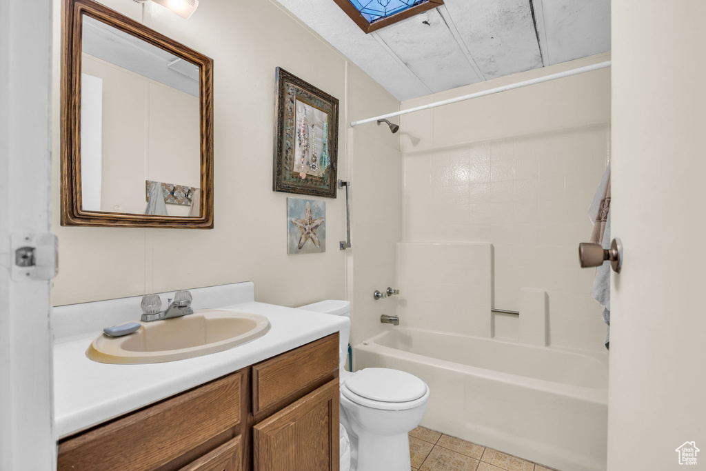 Bathroom with vanity,  shower combination, tile patterned flooring, and a skylight