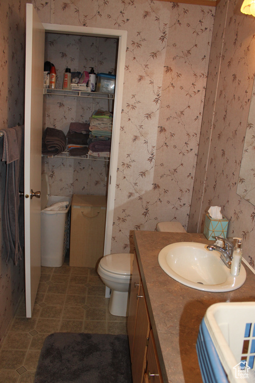 Bathroom with wallpapered walls and double vanity
