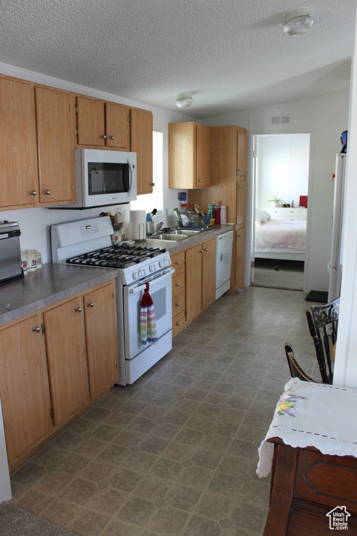 Kitchen featuring white appliances and a textured ceiling
