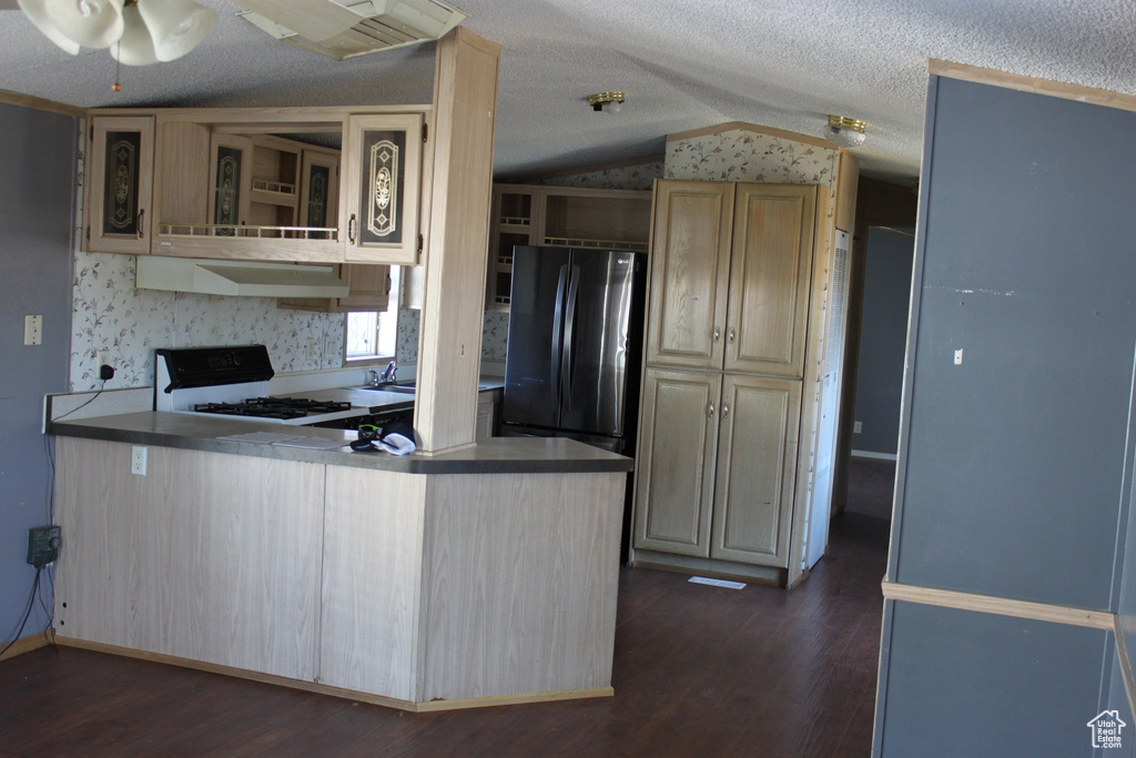 Kitchen featuring freestanding refrigerator, white range oven, vaulted ceiling, dark wood finished floors, and extractor fan