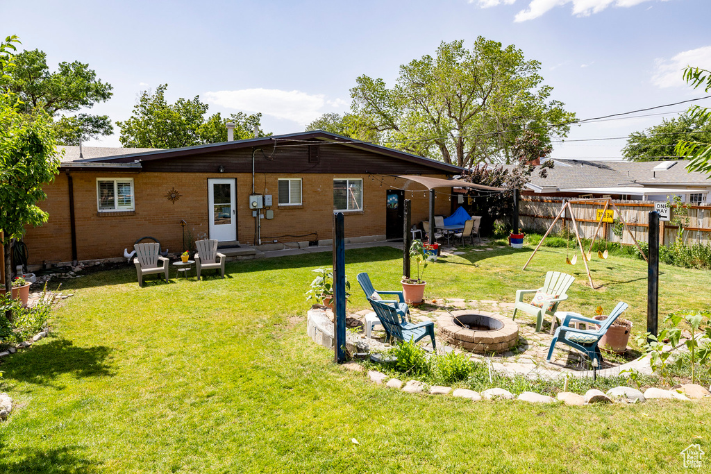 Rear view of house featuring an outdoor fire pit and a patio area