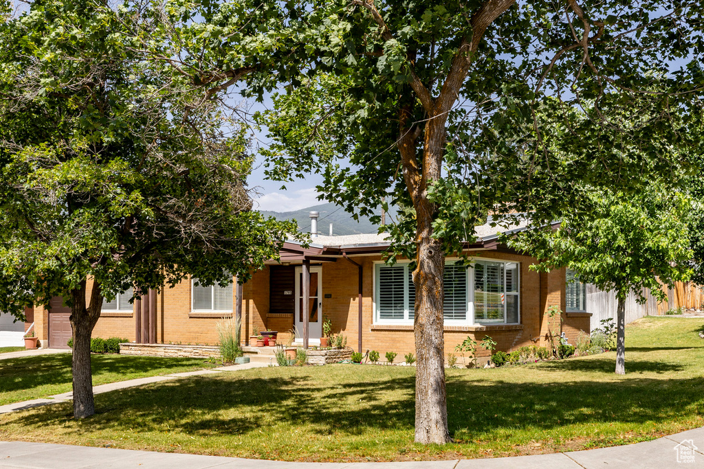 View of front of property featuring brick siding and a front lawn