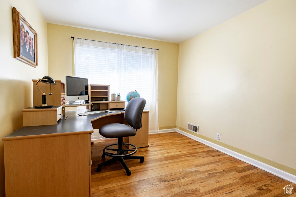Home office featuring light wood-type flooring and baseboards