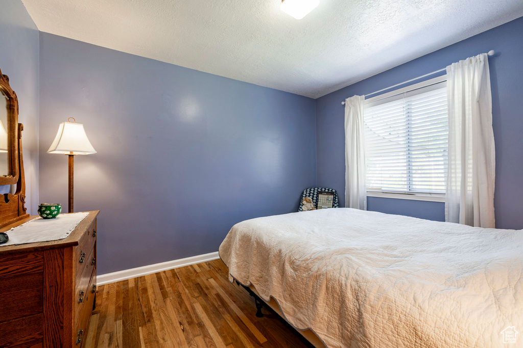 Bedroom featuring wood finished floors and baseboards