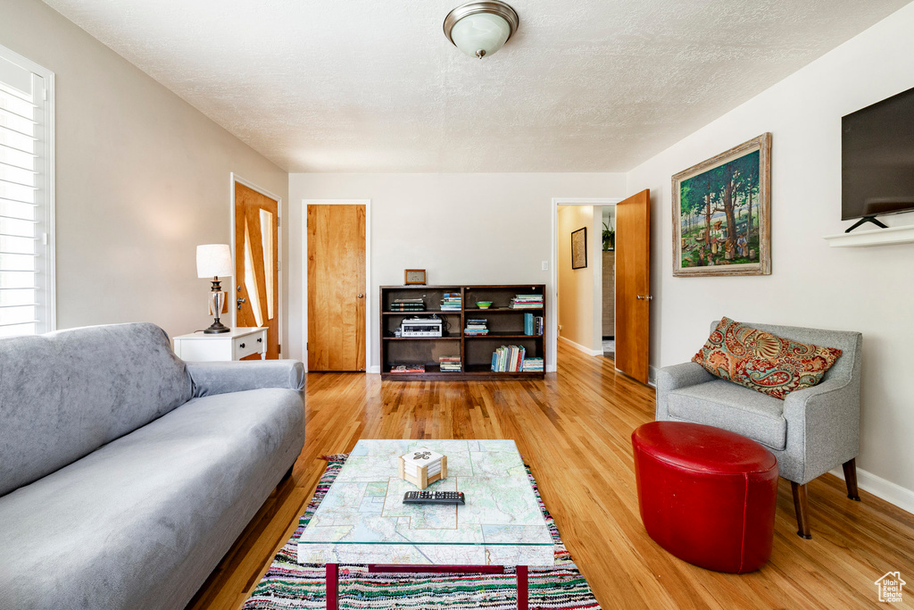 Living area featuring wood finished floors and a textured ceiling