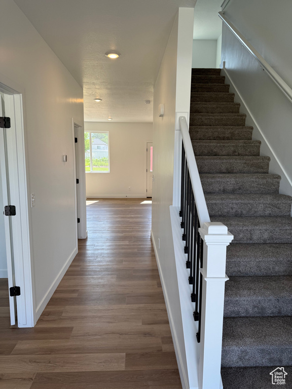 Stairway with wood finished floors and recessed lighting