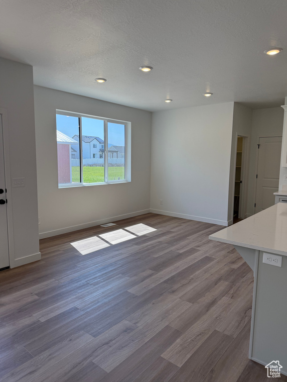Unfurnished living room with wood finished floors and recessed lighting