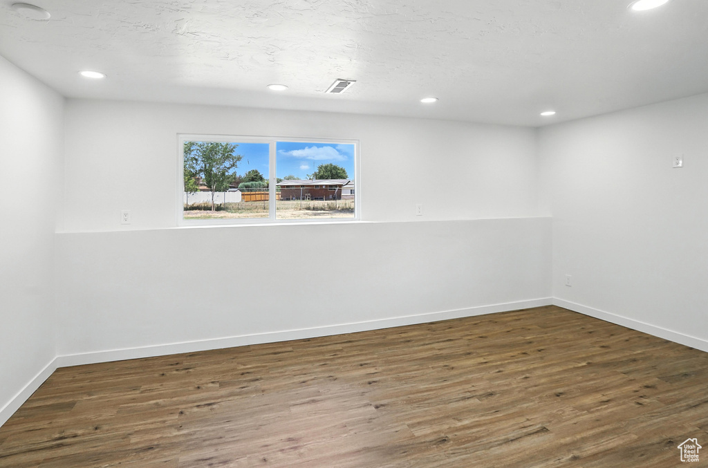 Unfurnished room with wood finished floors and recessed lighting