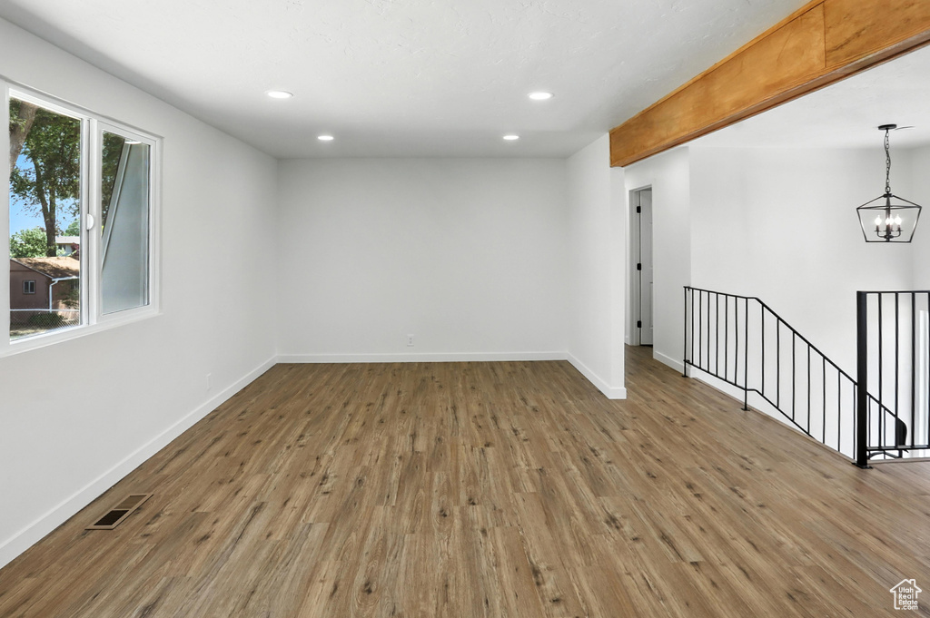 Spare room featuring wood finished floors, a chandelier, and recessed lighting
