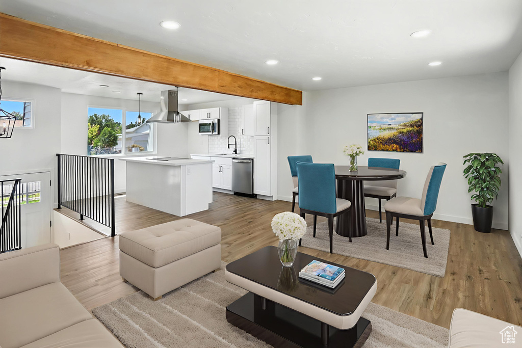 Living area with recessed lighting, wood finished floors, a chandelier, and beamed ceiling