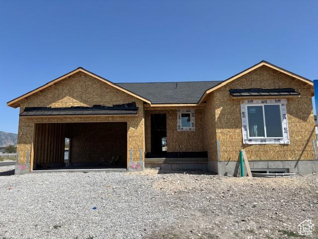 Property in mid-construction with a garage and driveway
