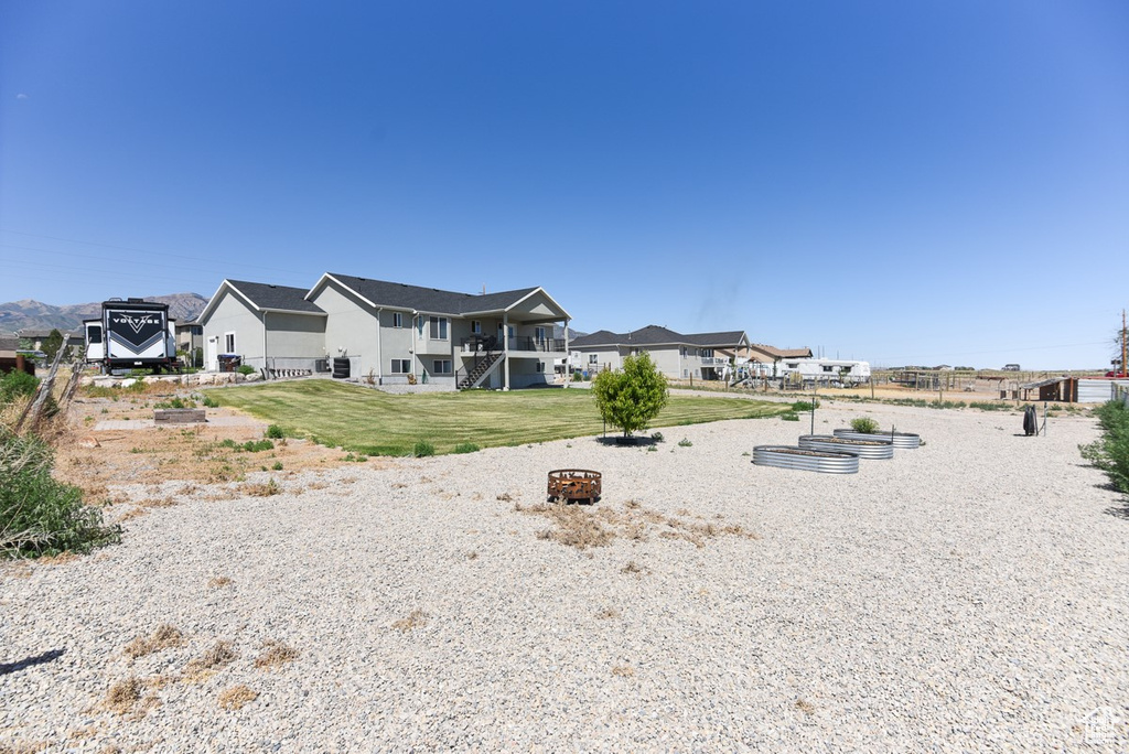 Back of house with a fire pit, a lawn, and a residential view