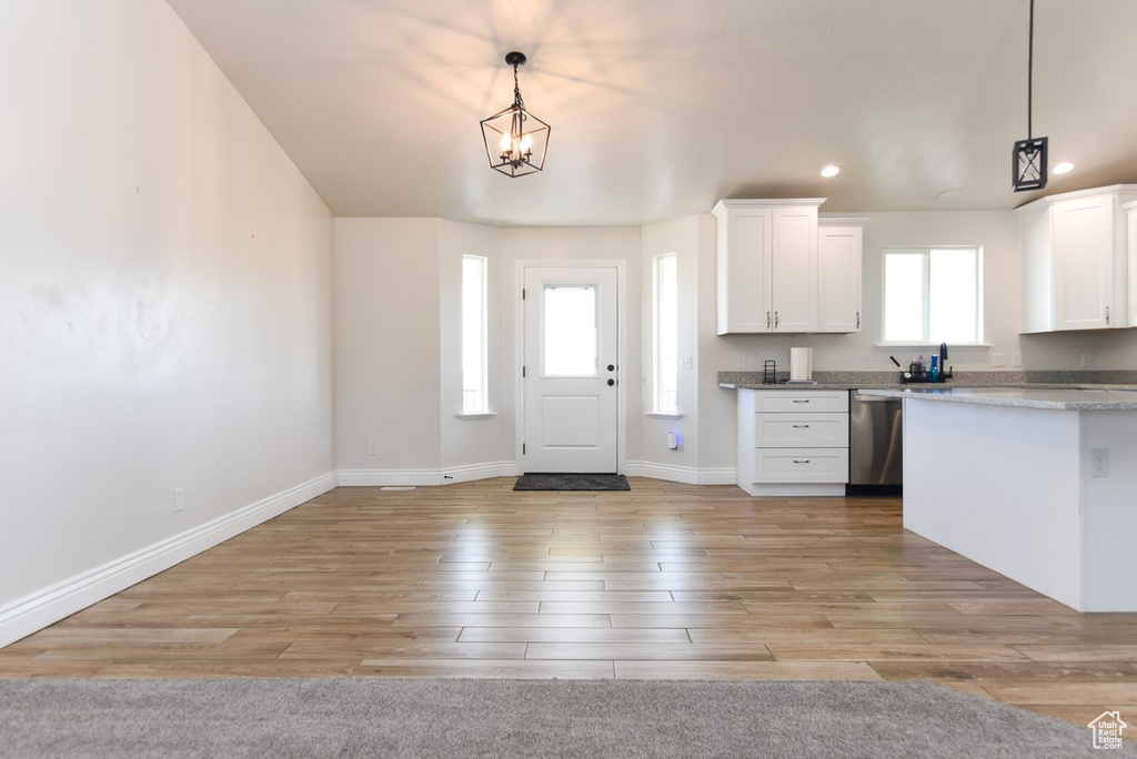 Kitchen with dishwasher, white cabinets, light wood finished floors, decorative light fixtures, and recessed lighting