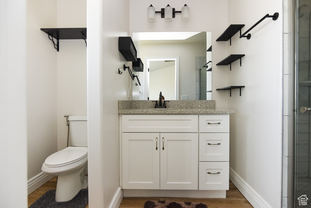 Bathroom with wood finished floors, vanity, and tiled shower