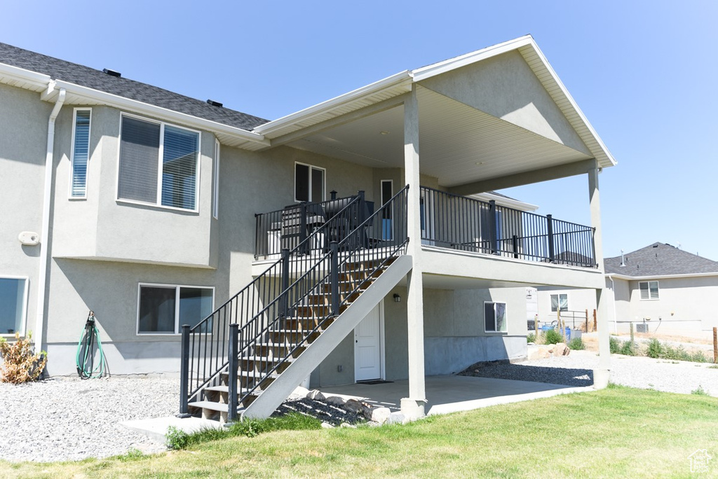 Back of house featuring stairway, stucco siding, and a patio area