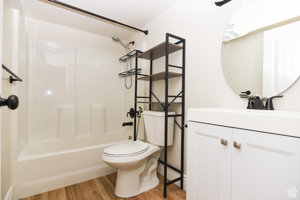 Bathroom featuring vanity, shower / washtub combination, and wood finished floors
