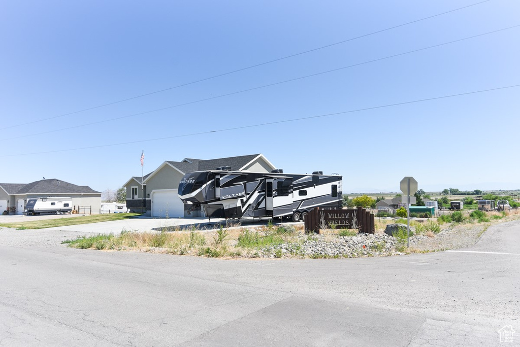 View of front of home featuring driveway, a residential view, and an attached garage