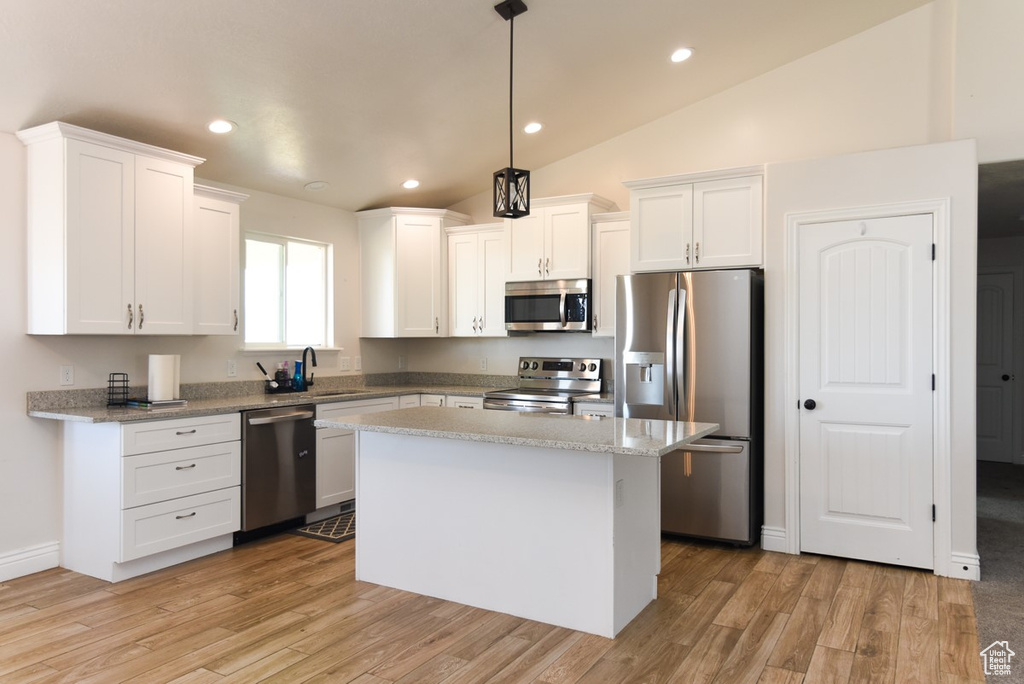 Kitchen with appliances with stainless steel finishes, white cabinetry, a kitchen island, light wood finished floors, and recessed lighting