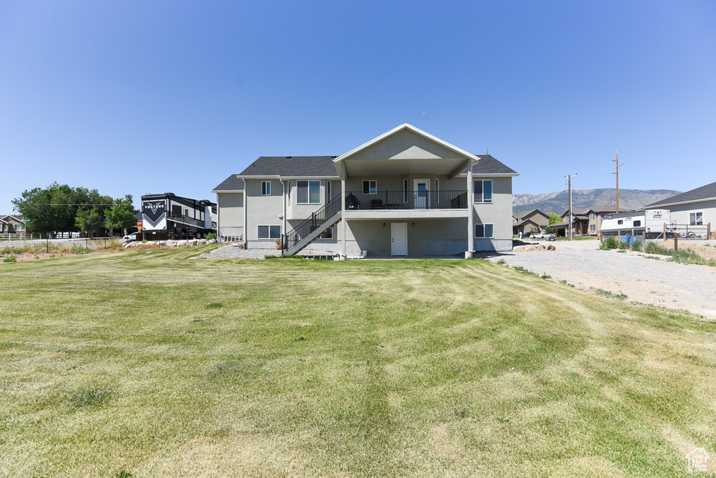 View of front of house featuring stairway, a front lawn, and stucco siding