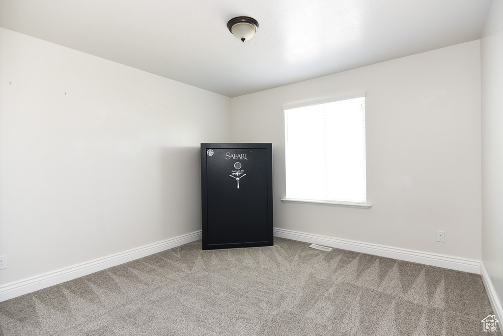 Spare room featuring carpet flooring and baseboards