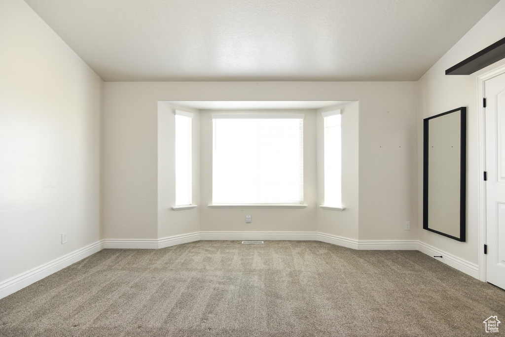 Empty room with carpet floors and baseboards