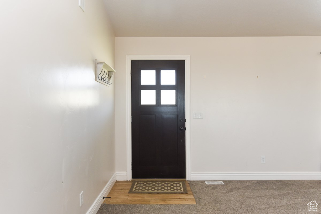 Doorway to outside featuring carpet flooring