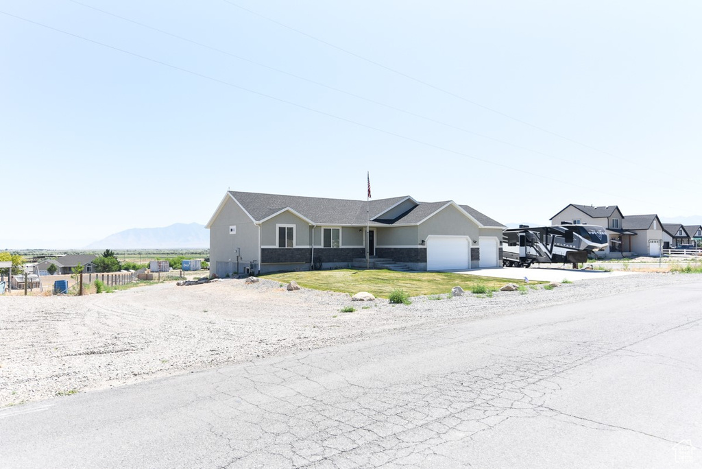 Single story home featuring an attached garage, driveway, and stucco siding
