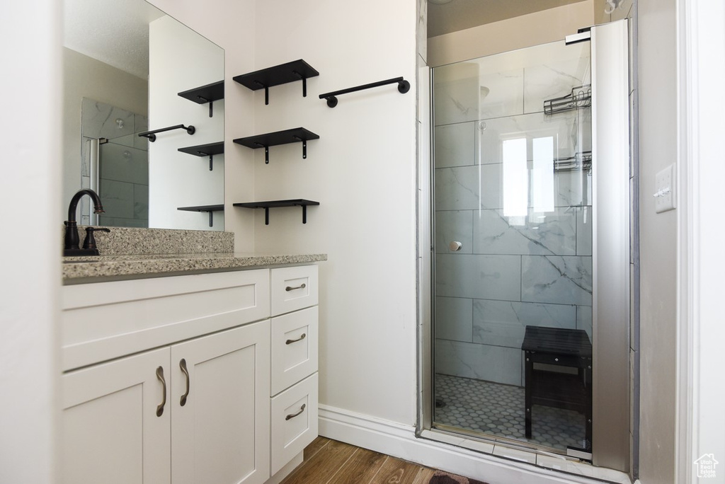 Full bathroom with a stall shower, wood finished floors, and vanity