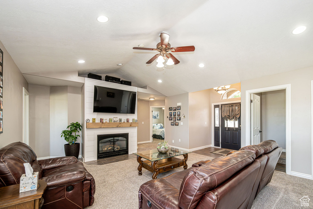 Living room with recessed lighting, ceiling fan, lofted ceiling, and a fireplace