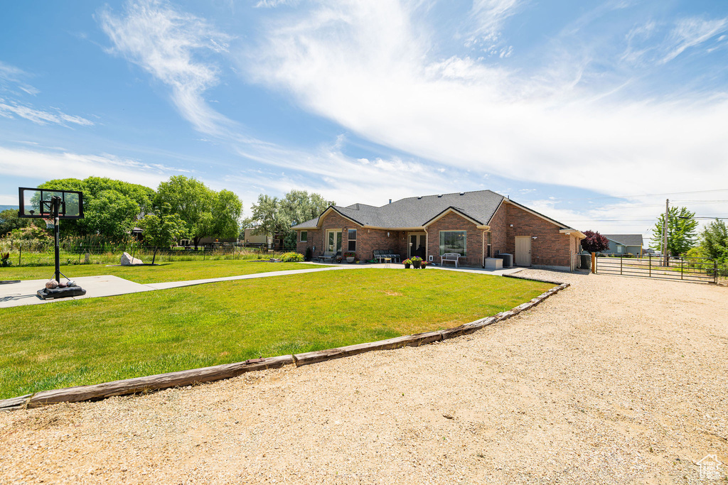 View of front of home featuring a patio area, brick siding, and driveway