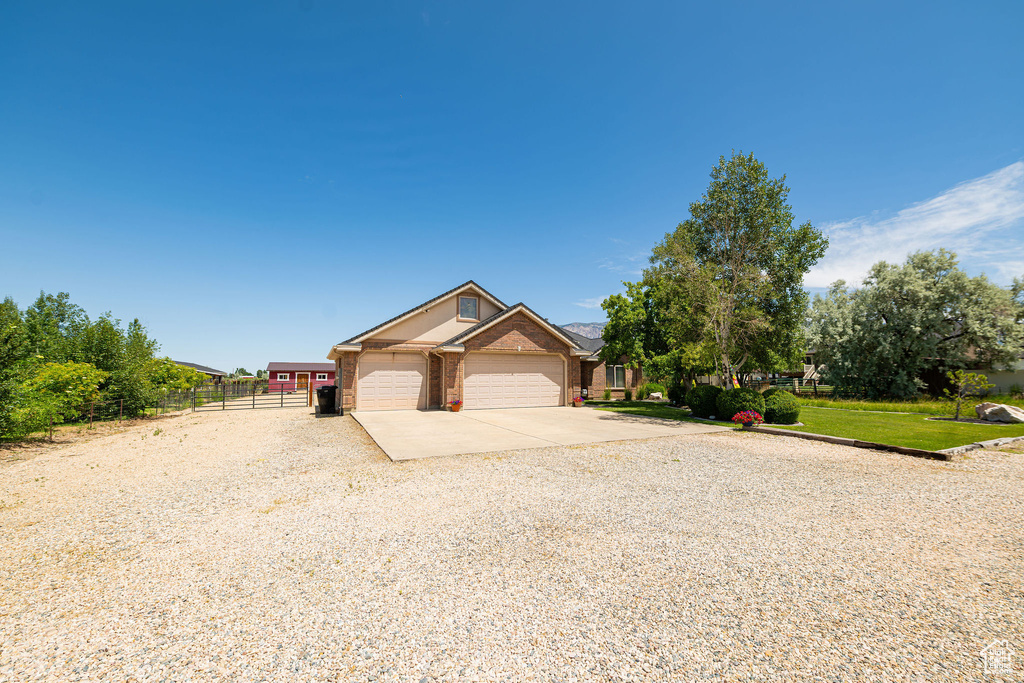 View of front of home with concrete driveway, a garage, and brick siding