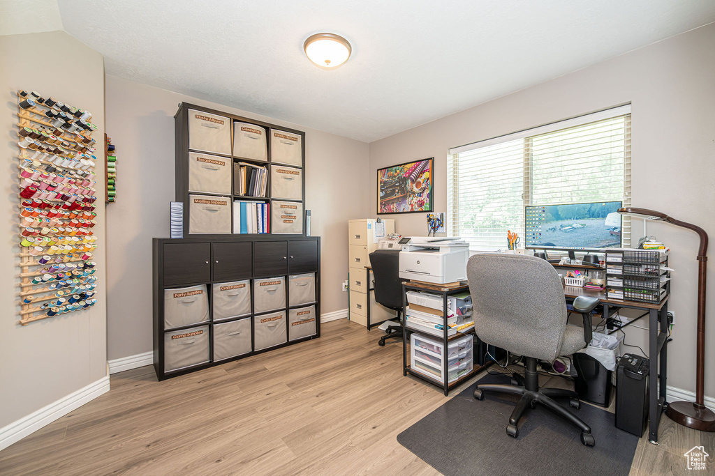 Office area with light wood-style flooring and baseboards