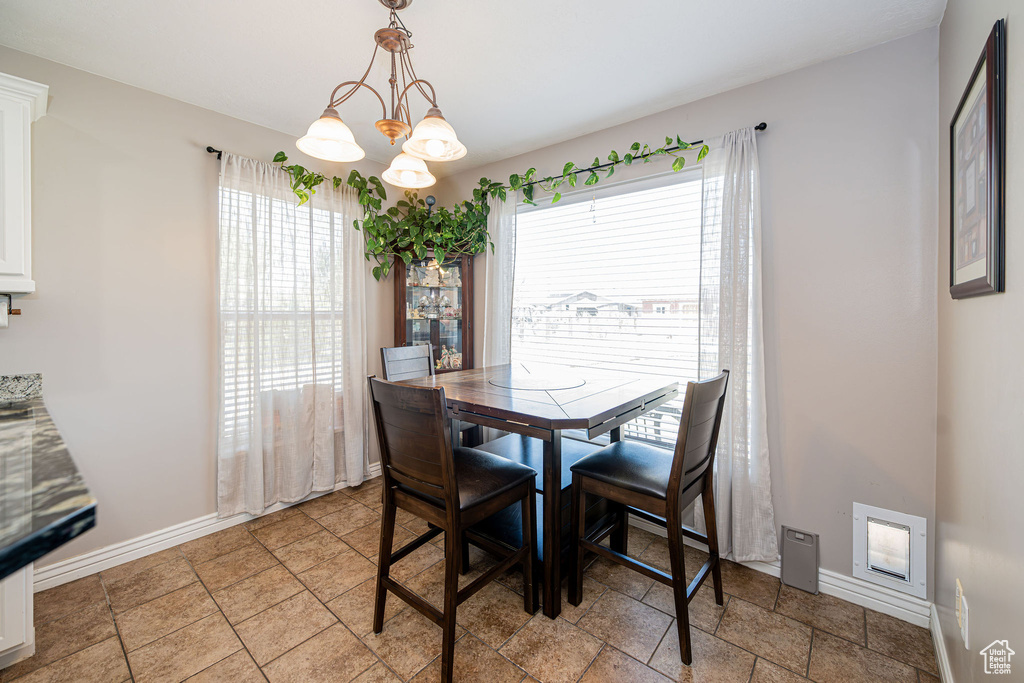Dining area featuring a chandelier and stone tile floors
